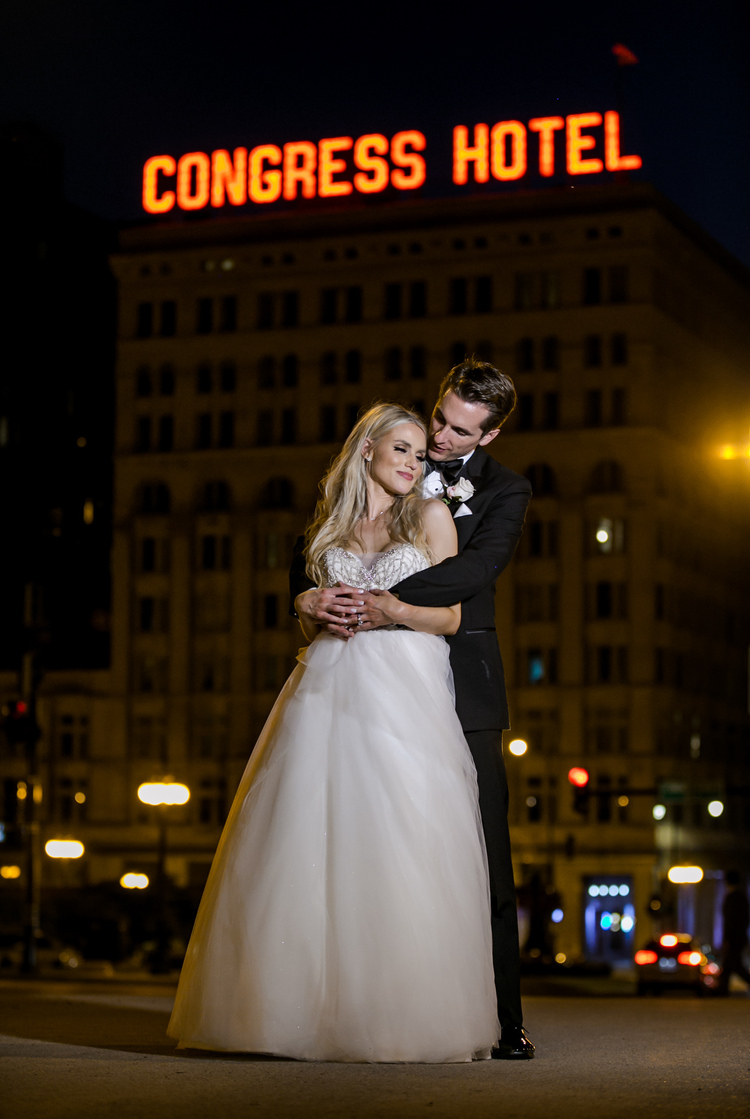 Bride and groom at night in front of Congress Hotel