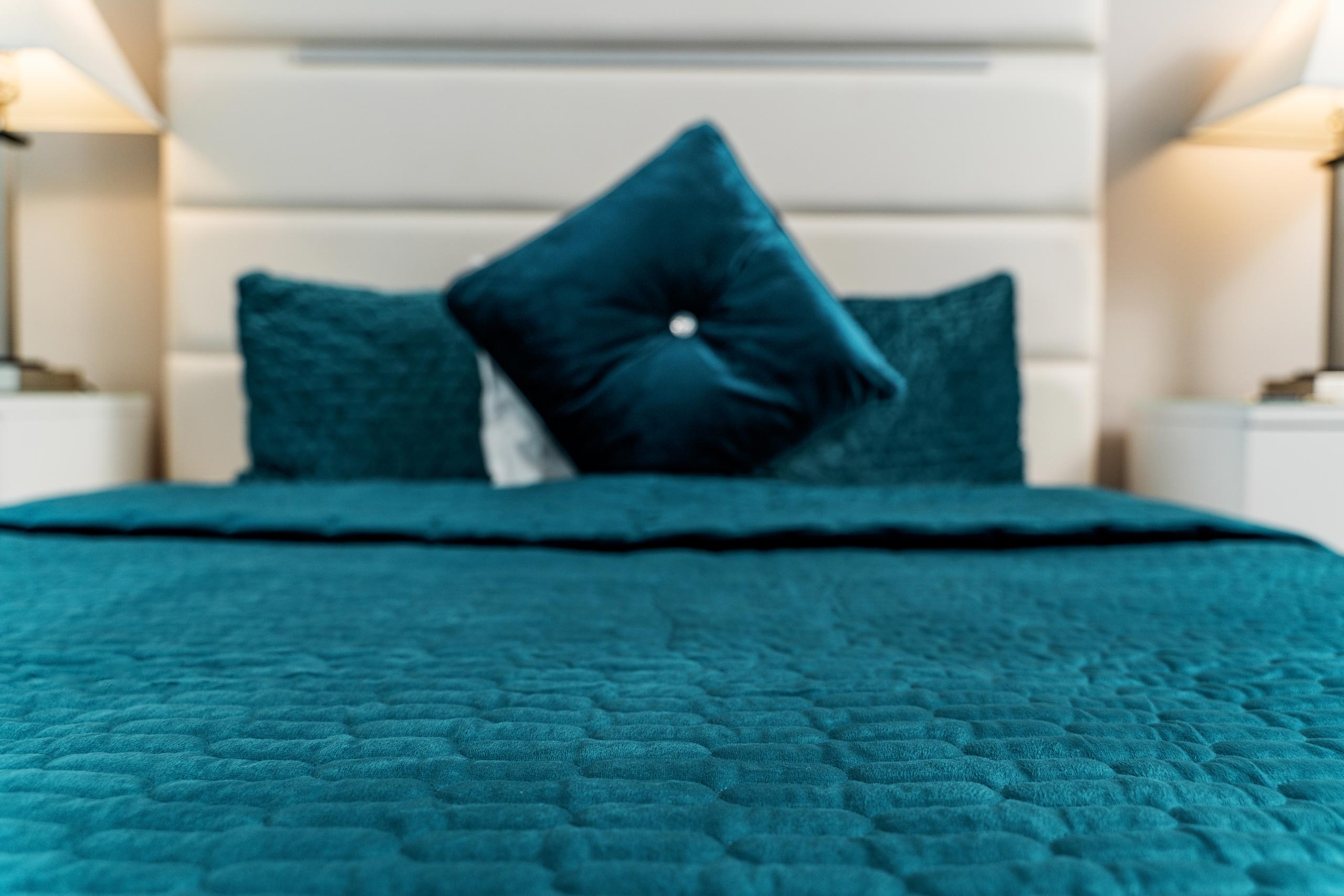 Bed with blue cover and pillows